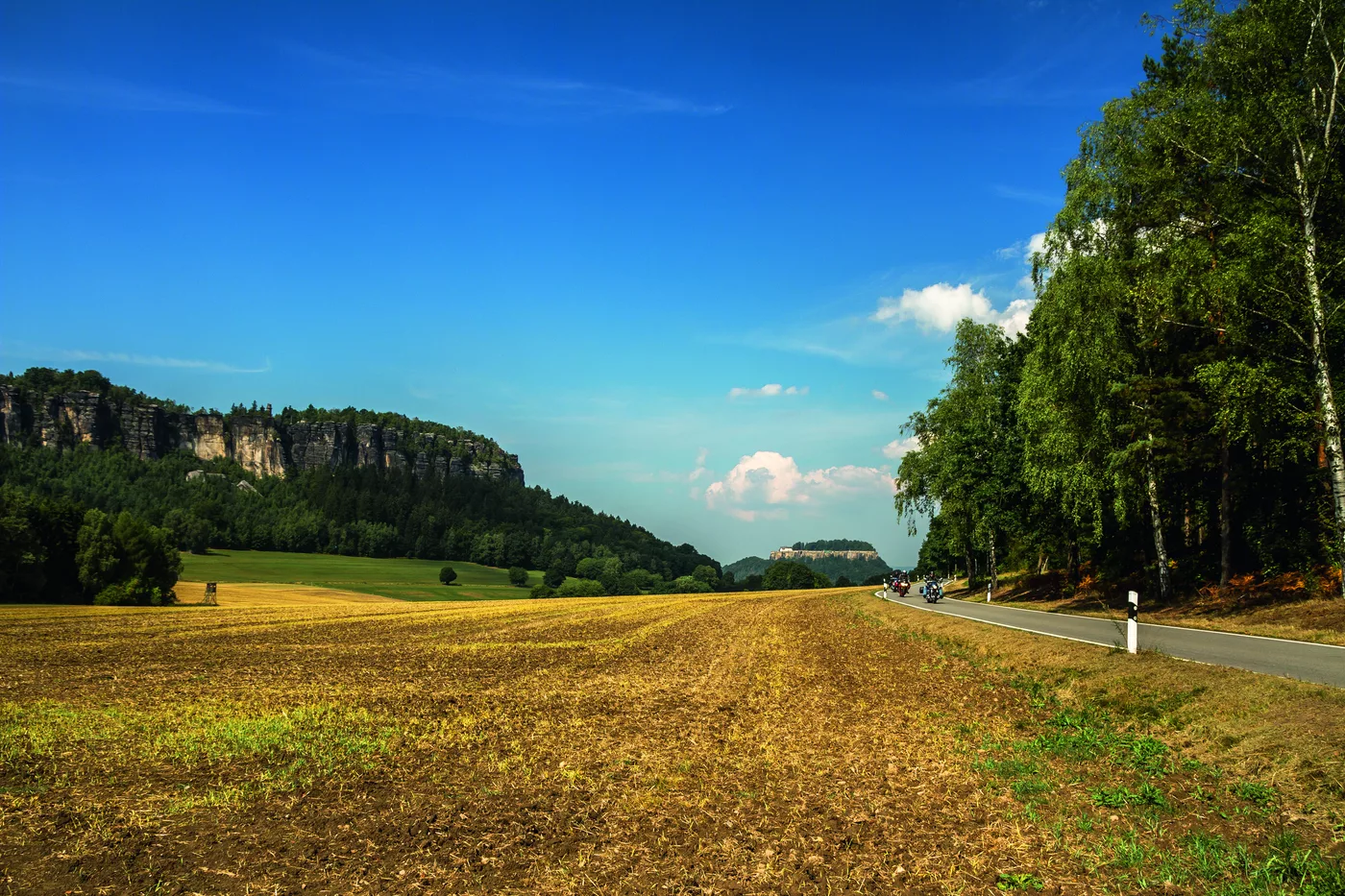 Sandstein-Tafelberge am Horizont über abgeernteten Feldern
